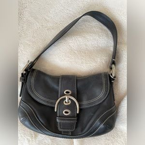 Black leather Coach purse with buckle on front